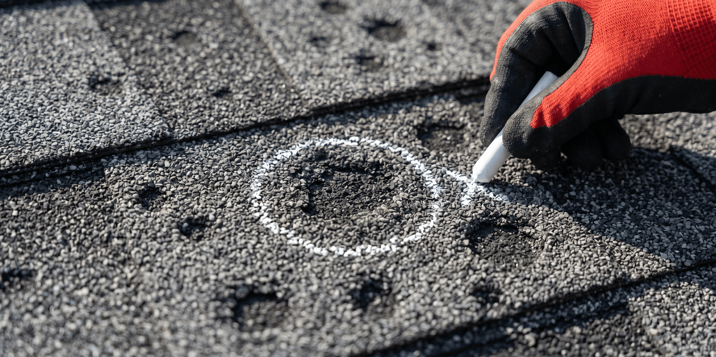 Calgary roofer documenting roof damage for an insurance claim with chalk markings and a written scope report